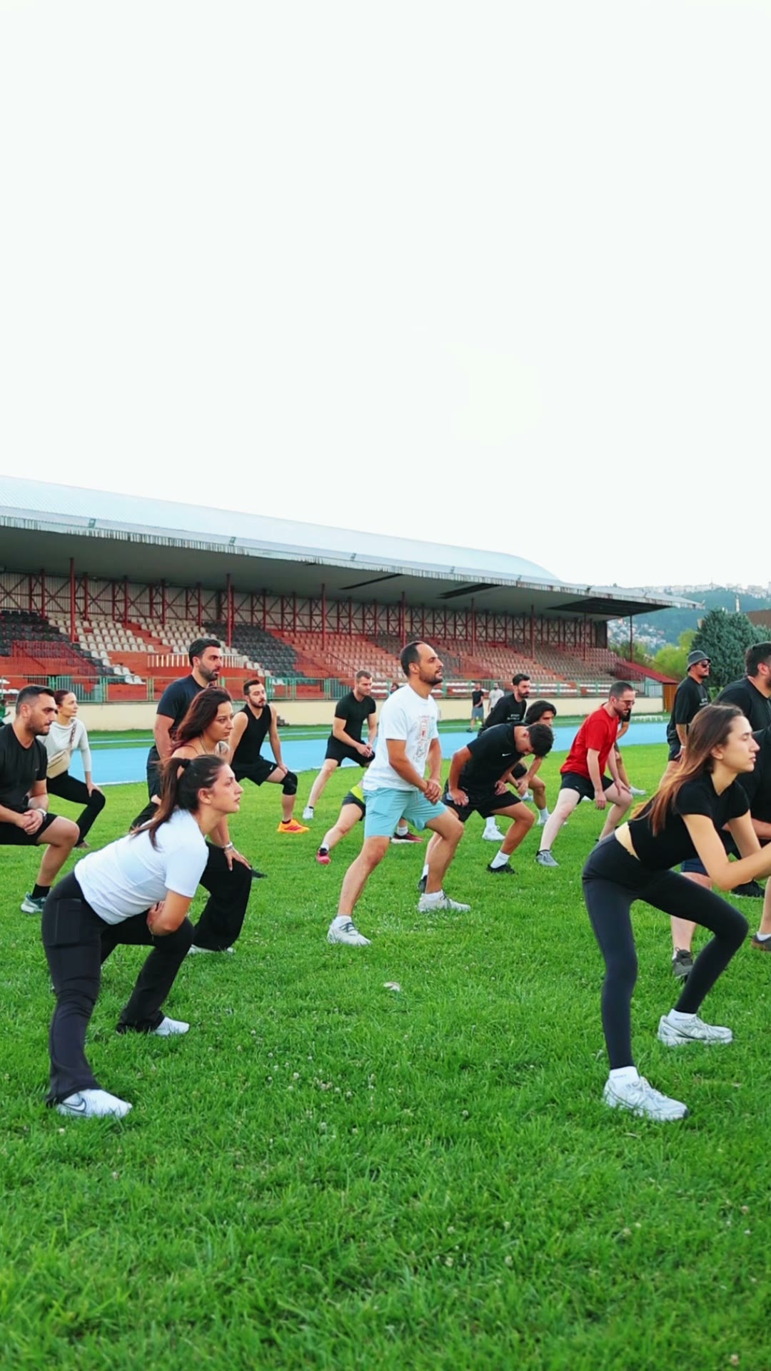 Eswith Runners Club üyeleri çim sahada birlikte ısınma hareketi yapıyor