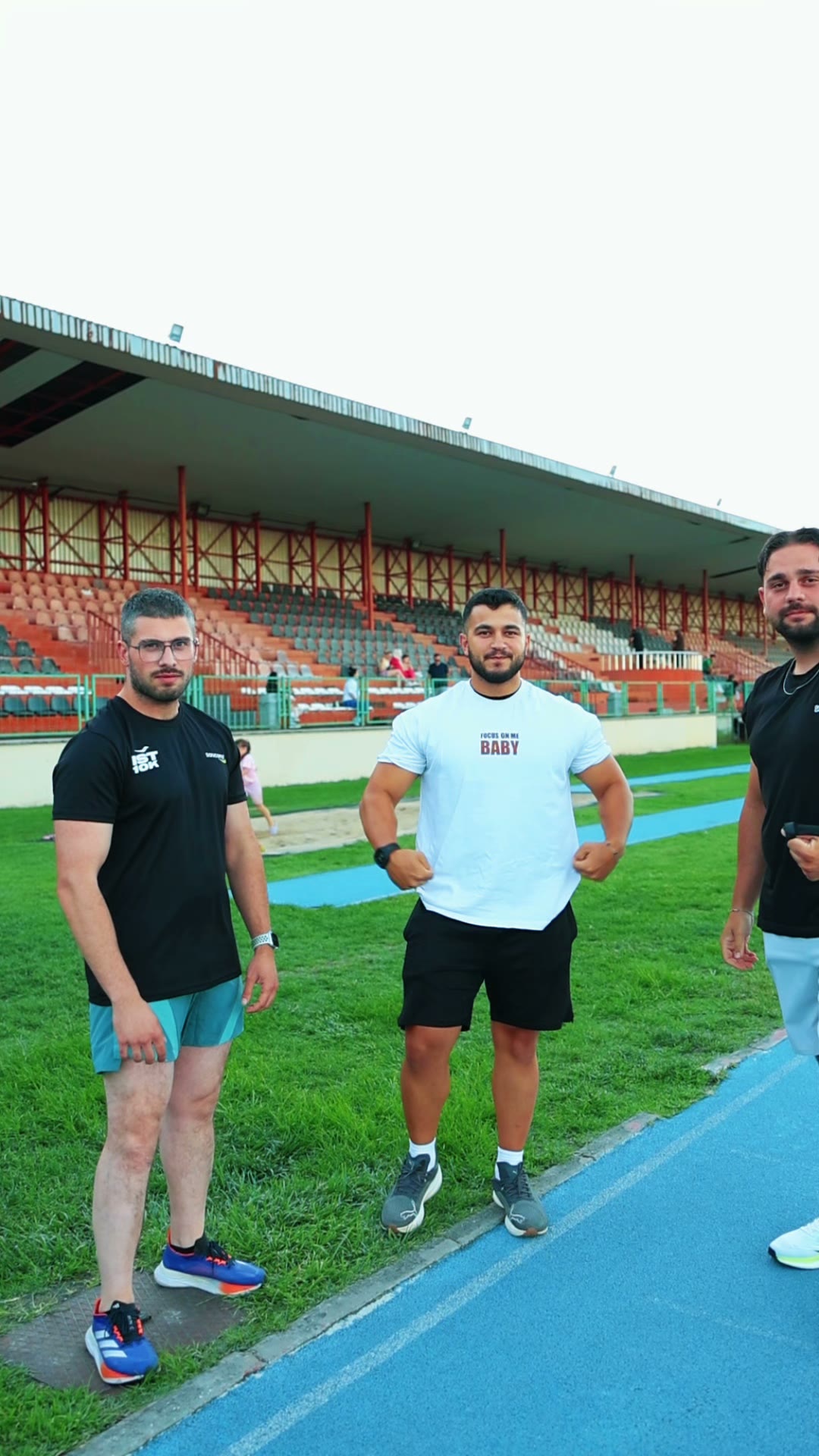 Kulüp üyeleri pist kenarında kameraya bakıyor